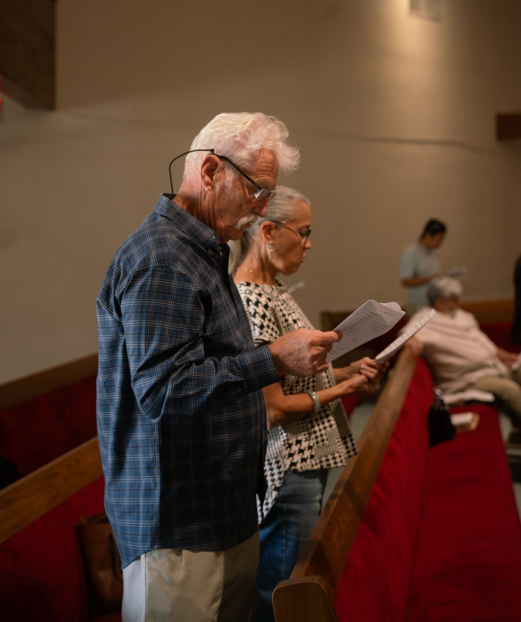 Couple singing from the hymn sheet