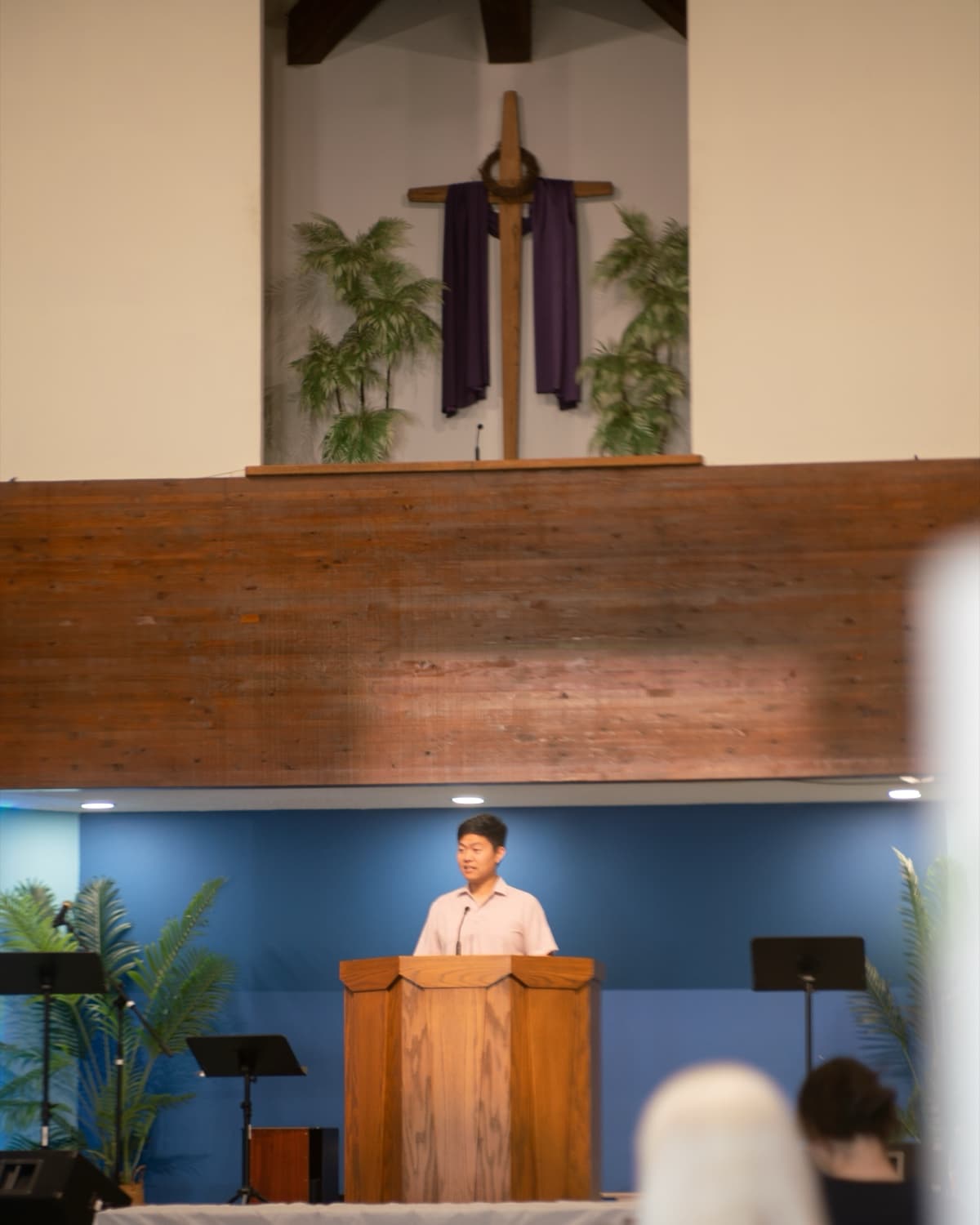 John Lee preaching from the pulpit beneath the cross at First Baptist Church of Artesia